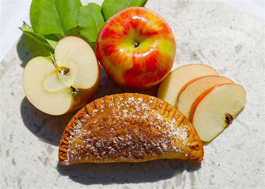 Apple empanada dusted with powdered sugar and cinnamon