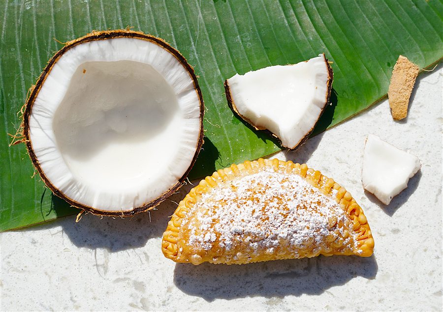Coconut empanada dusted with powdered sugar and cinnamon