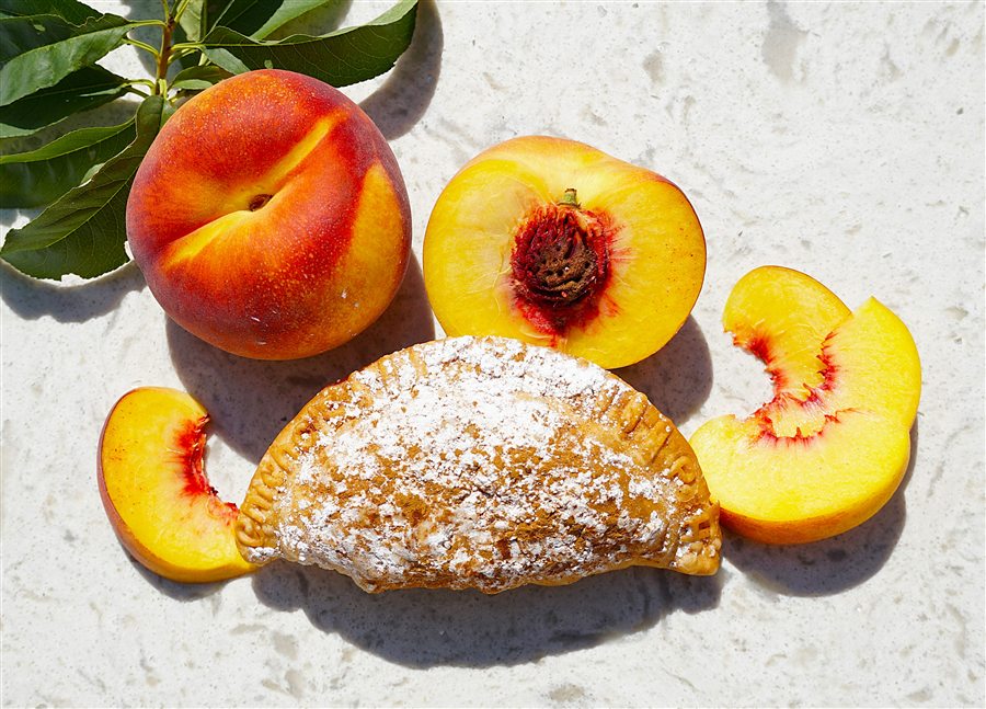 Peach empanada dusted with powdered sugar and cinnamon