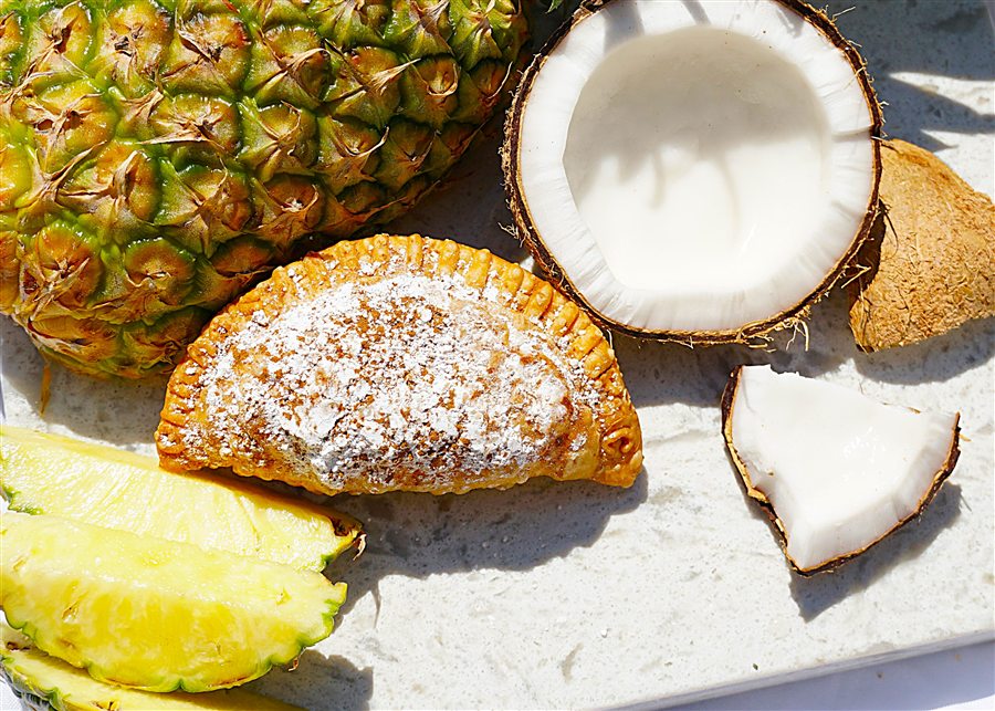 Pina colada empanada dusted with powdered sugar and cinnamon